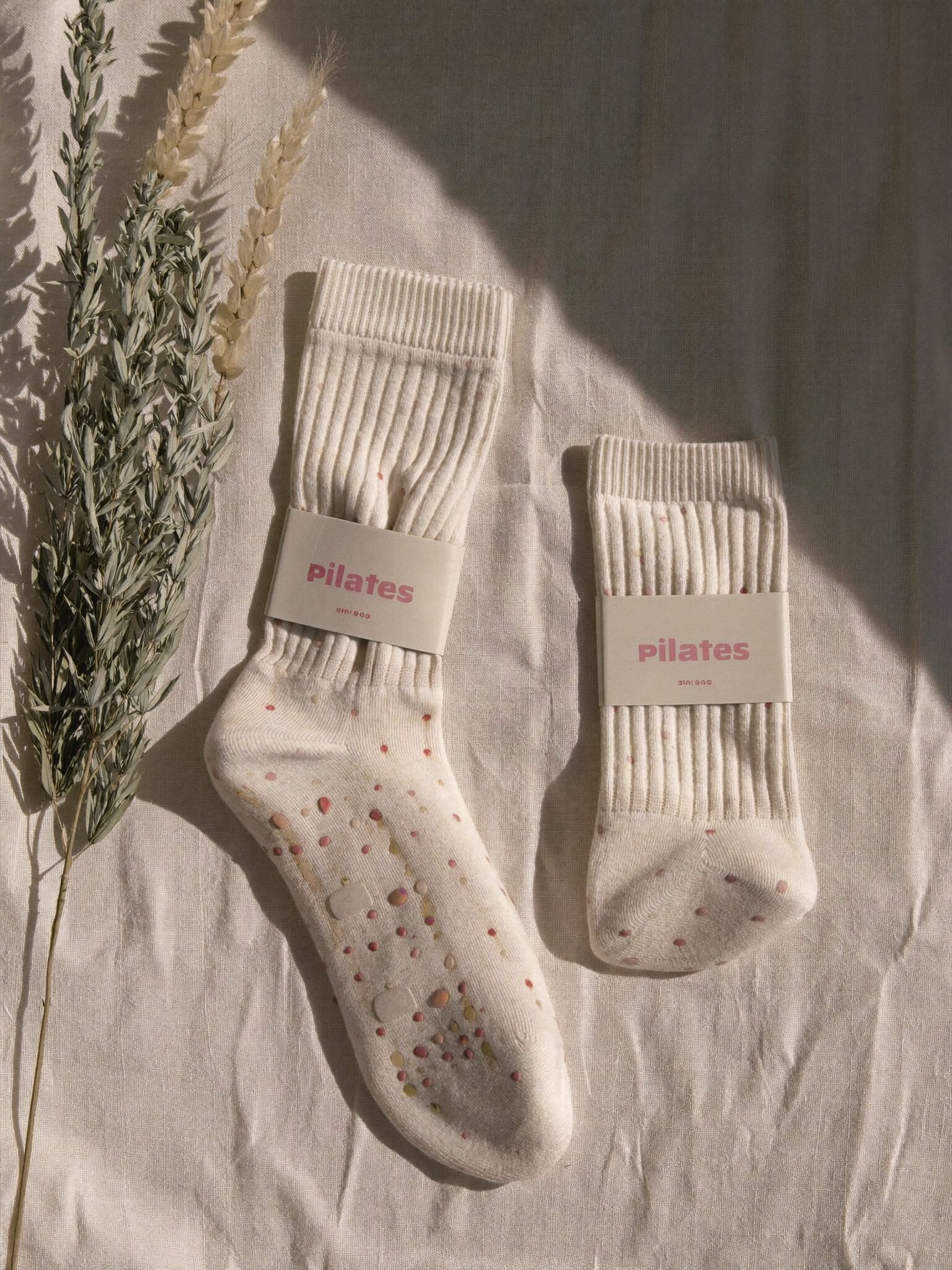 Ivory grip socks with blush silicone grips laid on linen